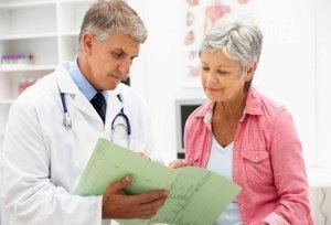 Woman with arthritis at the appointment of a doctor